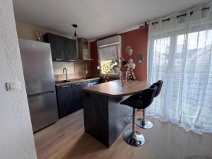 a kitchen with a island in the middle of a kitchen at Le Terracotta - Parking privé in Langres