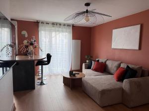 a living room with a couch and a table at Le Terracotta - Parking privé in Langres