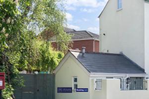 ein kleines weißes Haus mit schwarzem Dach in der Unterkunft Pet Friendly Cottage By KBS Stayhub Short Lets & Serviced Accommodation Stonehouse With Log Fire, Parking in Gloucestershire