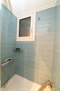 un bagno con doccia con finestra di Loutraki Cozy Central Appartment a Loutraki Altre 22 foto