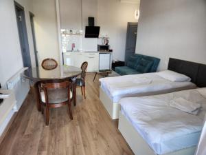a room with two beds and a table and a couch at Seventh Floor Apartment in Kutaisi +60 photos