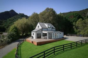 a house sitting on top of a lush green yard at Reotahi Bolthole in Whangarei Heads