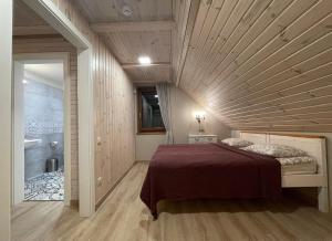 a bedroom with a bed with a wooden ceiling at River Mind Villa with SPA in Zalioji