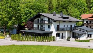 a large white house with a black roof at Stay Here Living Apartments in Thiersee