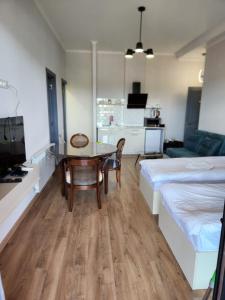 a living room with a dining room table and a bed at Seventh Floor Apartment in Kutaisi