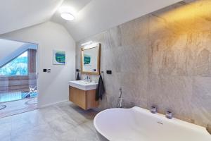 a bathroom with a tub and a sink and a mirror at Zrub Ontario, Tále in Horná Lehota