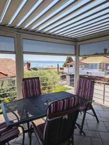 a screened porch with a table and two chairs at Apartments Miklus in Portorož