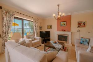 a living room with white furniture and a fireplace at Villa Mandalina, Cukurbag Peninsula-Kas in Kaş