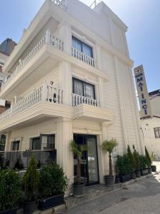 a white building with a balcony on top of it at Ber Mai İnci Hotel Antalya in Antalya