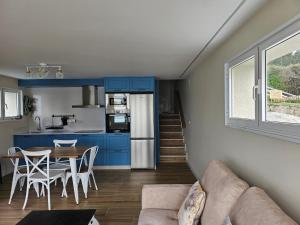 a kitchen and dining room with blue cabinets and a table at Casa Peñascales -Laxe- Costa da Morte in Laxe