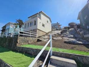 a house on top of a hill with some grass at Casa Peñascales -Laxe- Costa da Morte in Laxe