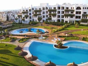 a large pool in front of a large building at Résidence Marina Beach in M'diq