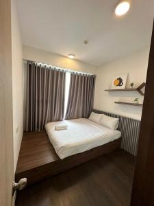 a small bedroom with a bed with a window at Mina Homie in Ho Chi Minh City
