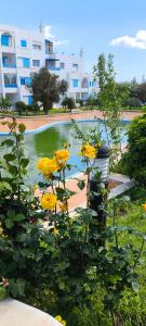 een vijver met gele bloemen voor een gebouw bij KABILA VISTA n3 in M'diq