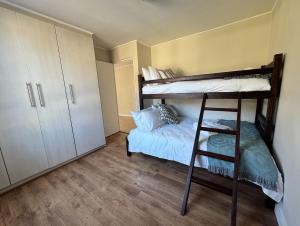 a bedroom with two bunk beds and a bed at Sea facing apartment in Hout Bay