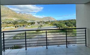 a balcony with a view of a road and mountains at Sea facing apartment in Hout Bay