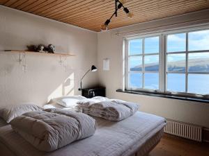 two beds in a room with a large window at Panoramic Holiday Home With 5 Bedrooms And Fjord in Vágur