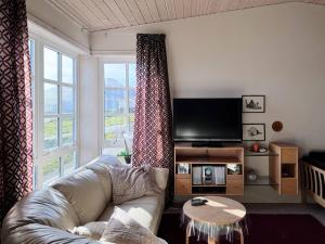 a living room with a couch and a large window at Panoramic Holiday Home With 5 Bedrooms And Fjord in Vágur