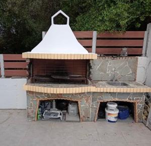 a brick oven with a white roof sitting next to a bench at Villa Nicolas Plataria in Plataria