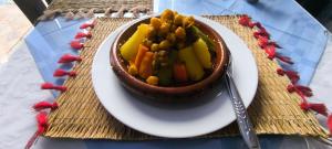 een kom groenten op een bord op een tafel bij KABILA VISTA n3 in M'diq