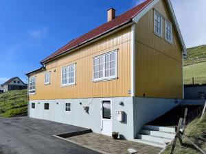 a large yellow and orange building with a driveway at Panoramic Holiday Home With 5 Bedrooms And Fjord in Vágur