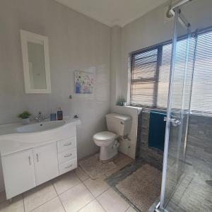 a bathroom with a toilet and a sink and a shower at 10 Seaverge in Port Edward +20 photos