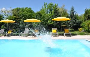 una fontana in una piscina con sedie e ombrelloni di Hotel Garni Toscanina - Adults Only a Bad Radkersburg