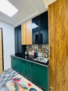 a kitchen with green cabinets and a sink at Velvet Vista in Ghaziabad