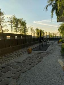 a stone walkway with a playground in a park at Ruang Hening in Seri Kembangan