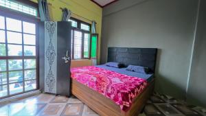 a bedroom with a large bed in a room with windows at Mahi Restaurant & Guest House in Almora