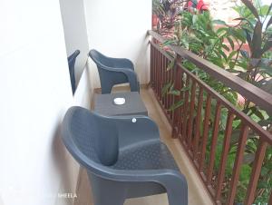 two blue chairs sitting on a balcony at Helix Guest House in Mandrem