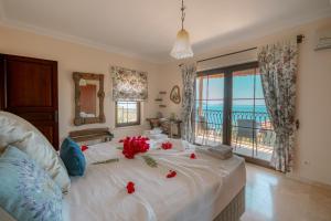 a bedroom with a bed with red flowers on it at Villa Limon, Cukurbag Peninsula-Kas in Kaş +44 photos