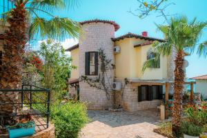 a house with a palm tree in front of it at Villa Limon, Cukurbag Peninsula-Kas in Kaş
