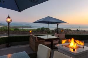a patio with a table and an umbrella and a fire pit at Butler Arms Hotel in Waterville