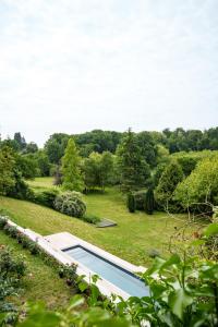 a swimming pool in the middle of a grass field at Élégante longère, piscine entre Tours et Amboise in Vernou-sur-Brenne