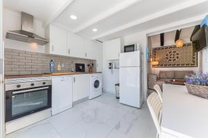 Il comprend un salon et une cuisine équipée d'appareils électroménagers blancs. dans l'établissement PETRA, à Dénia