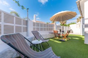 un patio avec des chaises, une table et un parasol dans l'établissement PETRA, à Dénia