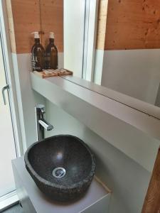 a bathroom with a black sink on a shelf at Red Kite Eco Bothy - with Hot Tub in Castle Douglas