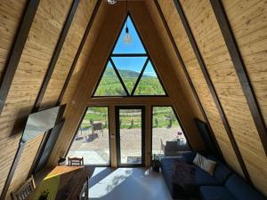 Cette chambre mansardée offre une vue sur un salon doté d'une grande fenêtre. dans l'établissement Dream Cottage A-Frame, à Şinca Nouă