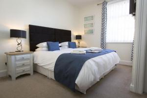 Un dormitorio con una cama grande con almohadas azules y una ventana. en Rosslyn House, en Whitby 51 fotos más