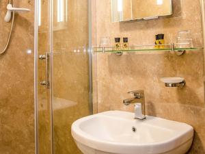 Un baño con lavabo y ducha de cristal. en Rosslyn House, en Whitby