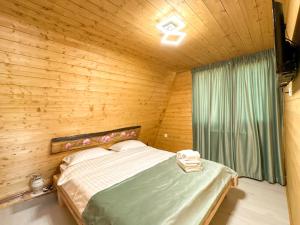 une chambre avec un lit dans une pièce en bois dans l'établissement Dream Cottage A-Frame, à Şinca Nouă