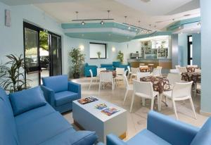 a restaurant with blue couches and tables and chairs at Hotel Continental in Tortoreto Lido