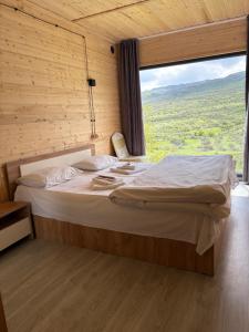 a bedroom with a large bed with a large window at Old Byurakan Cottage in Byurakan