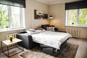 a bedroom with a bed and a table and windows at Centrum Apartment in Valga