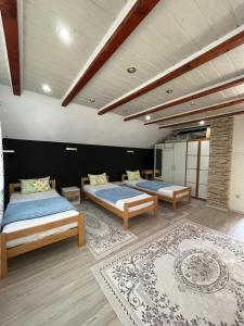 a bedroom with two beds and a rug at Family Flower House in Sarajevo