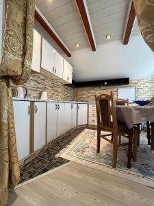 a kitchen with white cabinets and a table in a room at Family Flower House in Sarajevo