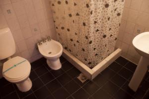 a bathroom with a toilet and a sink and a shower at Hostería La Pergola in Villa Serranita