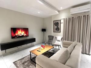 a living room with a couch and a fireplace at Luxor Apartments & Suites - Opus in Lahore