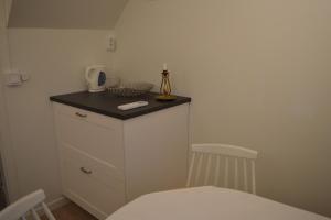 a small kitchen with a counter and a table and chair at Litet mysigt hus i Östra Göinge in Västraby +6 photos